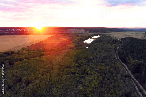 Flight in the beautiful countryside among a river of woods and fields near the city