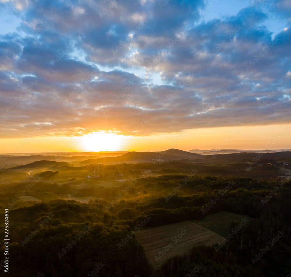 Aerial view of sunrise in foggy morning, forest and field in the foreground, view from air Aerial view of sunrise in foggy morning, forest and field in the foreground, view from air