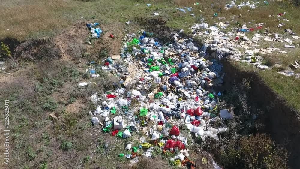  People threw garbage outside the city into the pit. All this pollutes the environment. Many multicolored packets - red, green, blue, white. The wind pumps the grass that grows here.