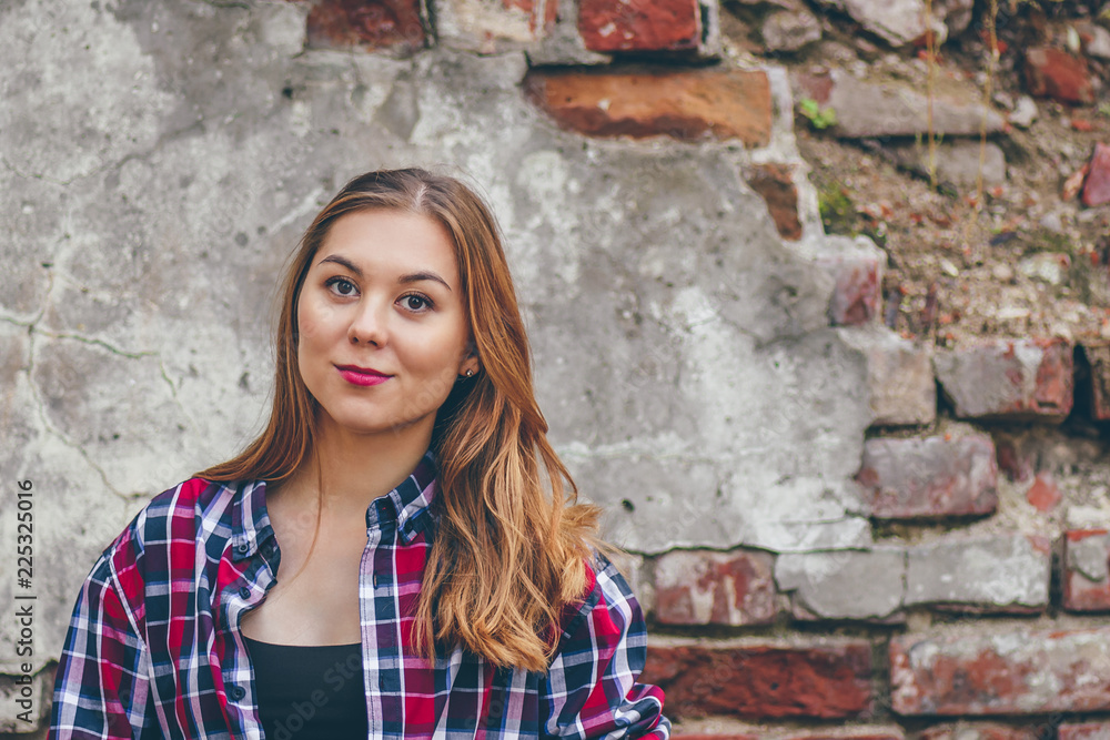 Beautiful girl is standing against brick wall Beautiful girl is standing against brick wall
