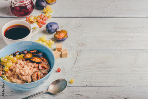 Porridge with plum, grapes and cup of coffee photo