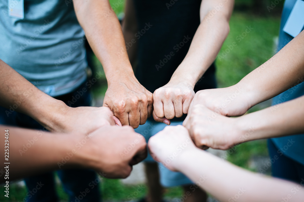 Close up of students standing hands making fist bump gesture. Close up of students standing hands making fist bump gesture.