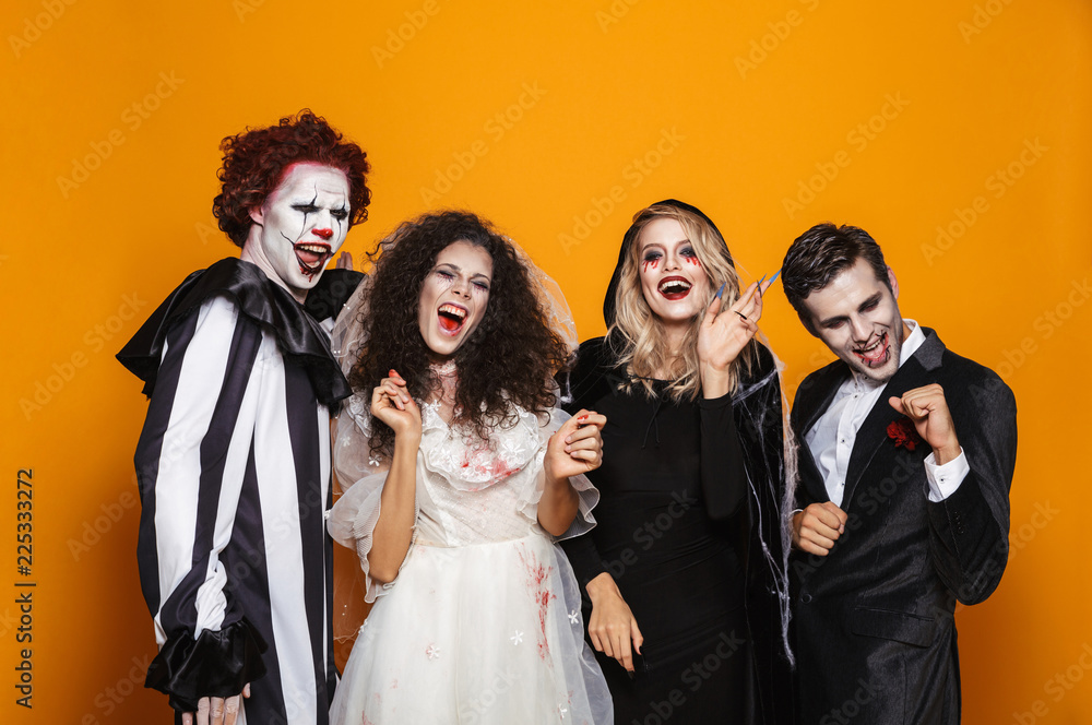 Group of positive friends dressed in scary costumes