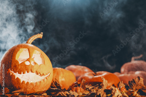 Image of a jack-o-lantern and pumpkins on a dark background, real photo with copy space photo