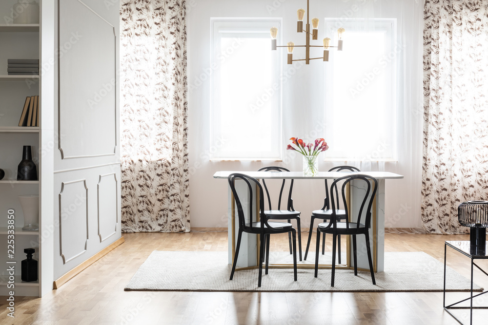 Real photo of a cozy dining room interior with patterned curtains, table, chairs and wall molding Real photo of a cozy dining room interior with patterned curtains, table, chairs and wall molding