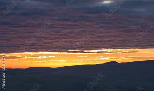 Colorful Sunrise Clouds over Hilly Countryside photo