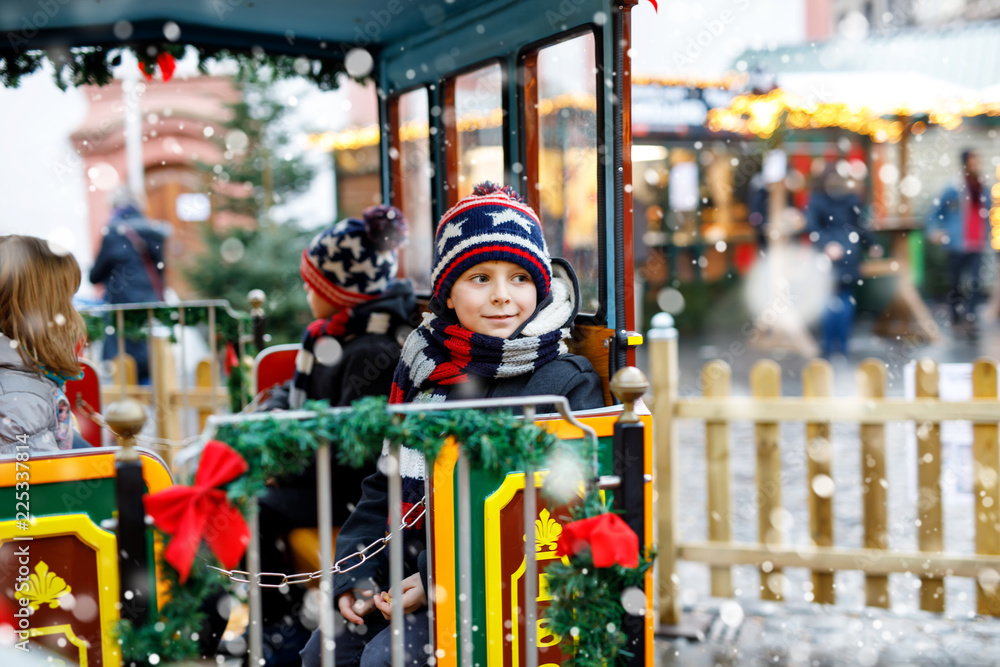 Obraz premium Little kid boy on carousel at Christmas market
