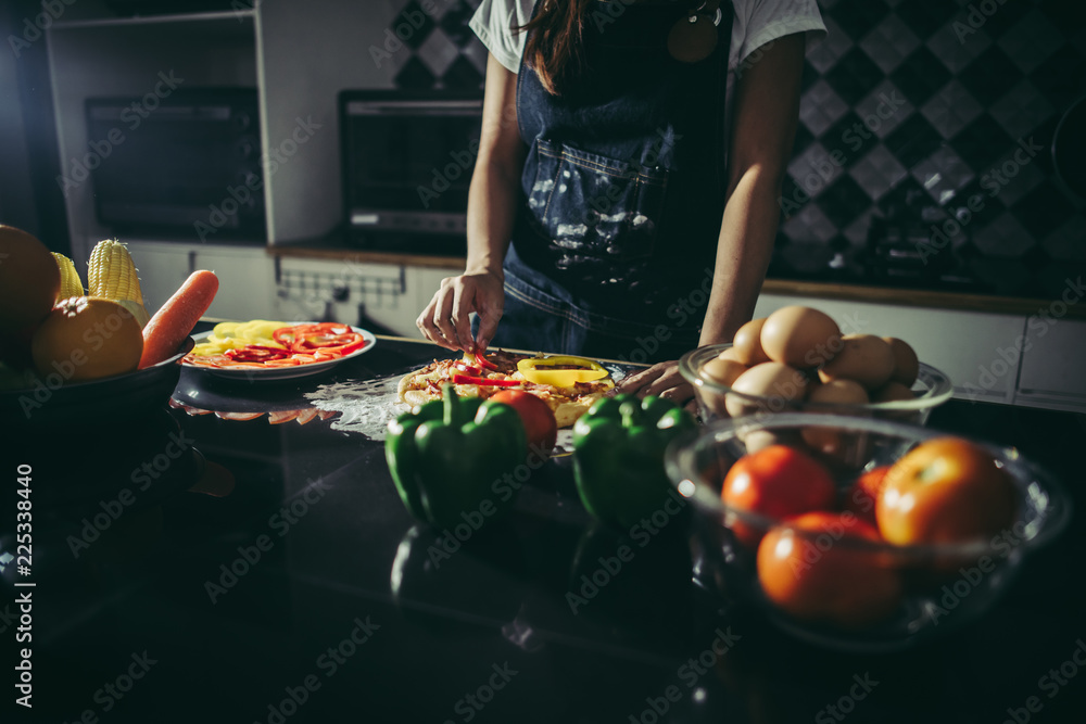 Close up of woman hand put topping on homemade pizza. Close up of woman hand put topping on homemade pizza.