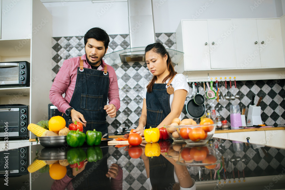 Happy couple cooking together in the kitchen at home. Couple concept Happy couple cooking together in the kitchen at home. Couple concept