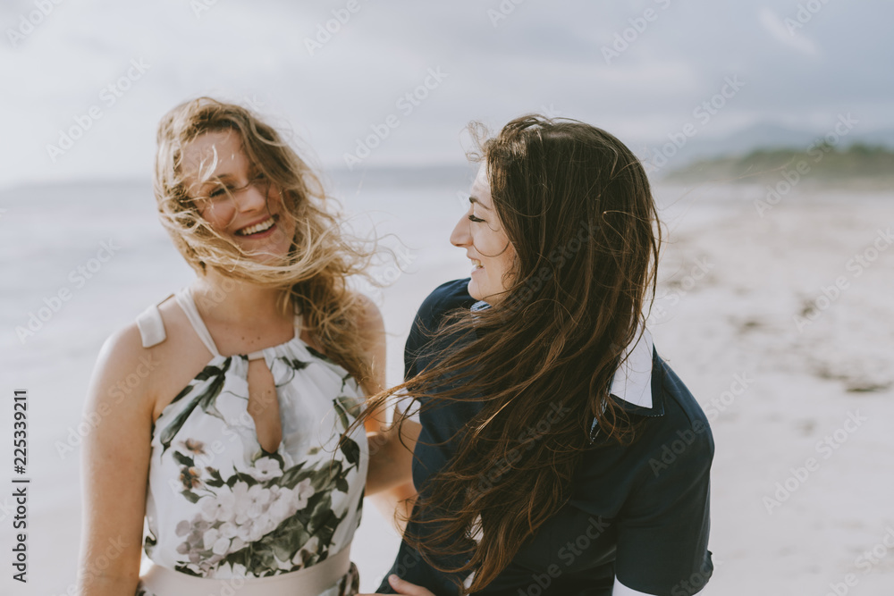 Young couple in love hug each other on the deserted beach on a summer evening