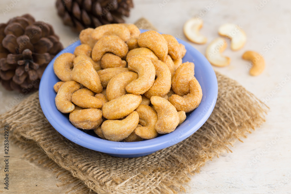 roasted cashew nuts in blue bowl, selective focus