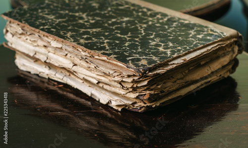 Ancient medieval worn books with yellow sheets stacked on a table