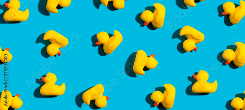 Collection of yellow rubber ducks on a blue background © Tierney