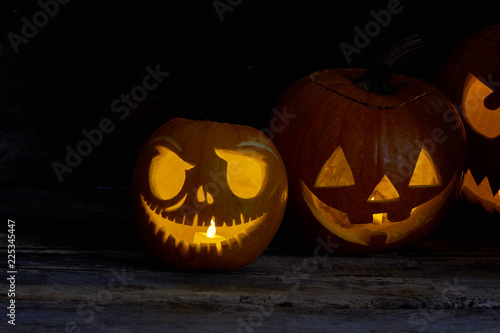 Halloween pumpkins with glowing candles. Group of glowing pumpkins at night. Happy Halloween concept.