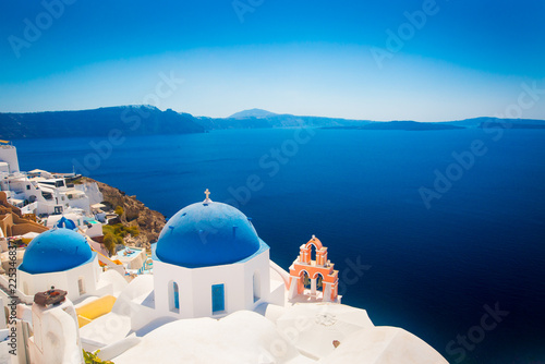 Oia town on Santorini island, Greece. Traditional and famous houses and churches with blue domes over the Caldera, Aegean sea (color toned image)