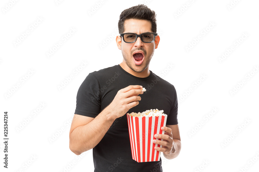 Fototapeta premium Scared Young Man Wearing 3D Glasses While Having Popcorn