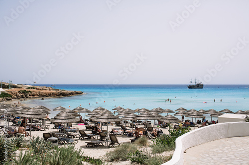 Straw umbrellas on the beach, blue paradise blue water, blue sky, Cyprus