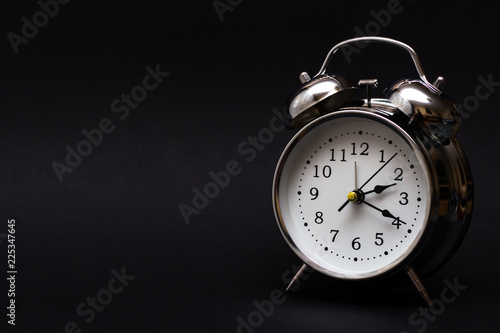 black retro alarm clock in dark background.For time concept.