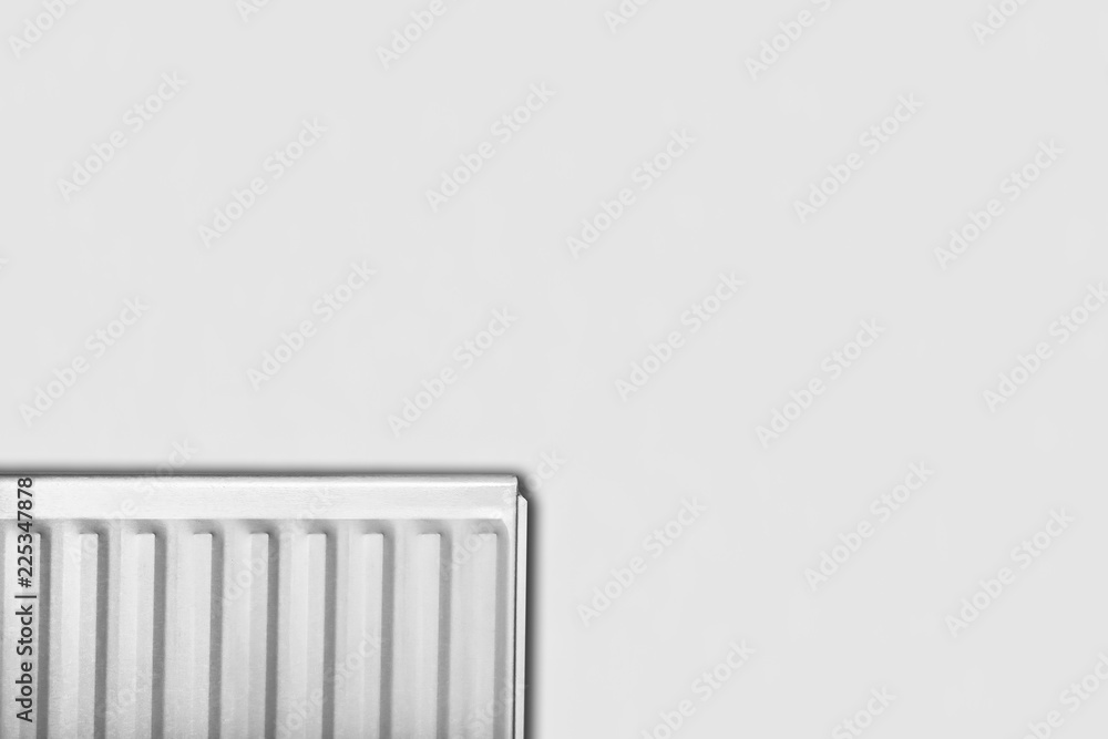 Hot water radiator in white isolated against a white wall with copyspace