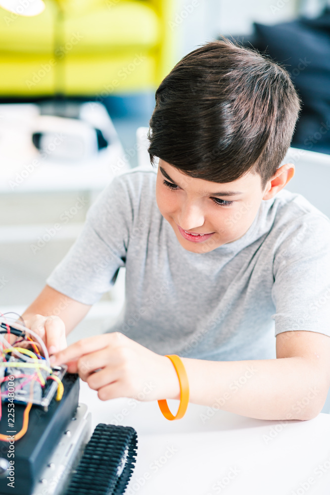 Smart positive schoolboy constructing a robotic device Smart positive schoolboy constructing a robotic device