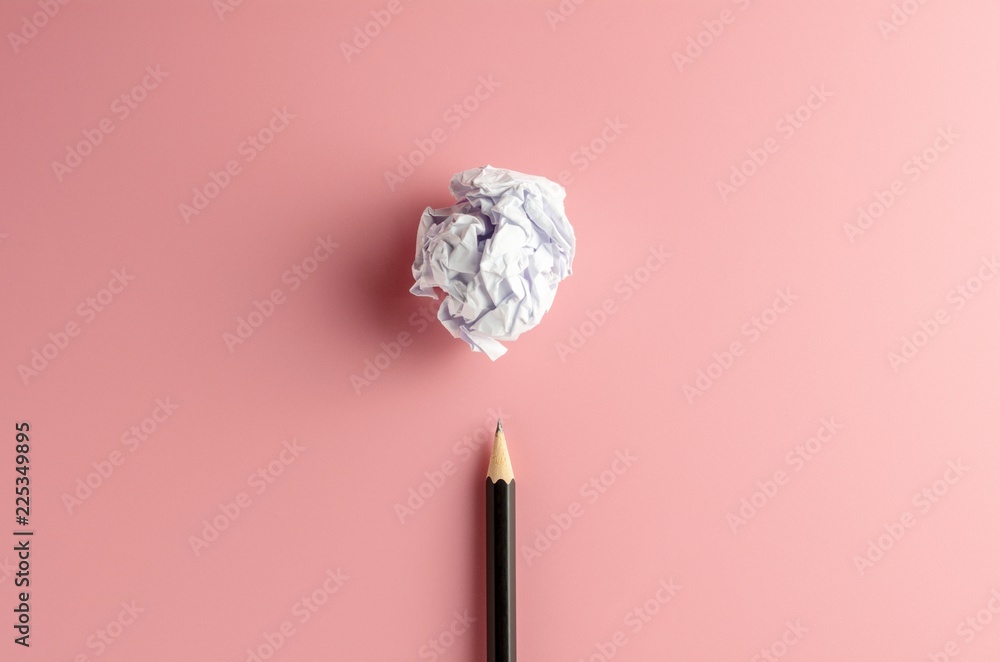pencil and a crumpled paper ball on pink paper background. - Business concept, symbol of key point and ideas.