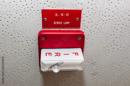 Red Fire alarm switch on the wall next to the door,Fire alarm switch.Break glass and pull down button to activate for warning and security system with hand and direction arrow,