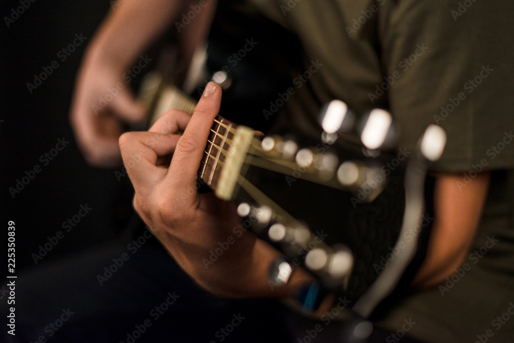 hands play on acoustic guitar
