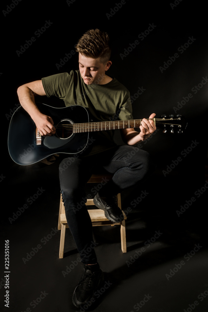 Obraz premium Guy in studio play on acoustic guitar