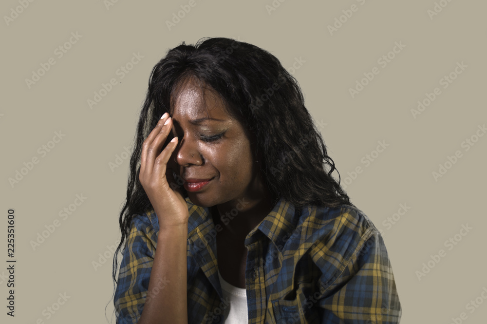 young sad and depressed black African American woman crying anxious and overwhelmed feeling sick and stressed isolated on studio background suffering depression