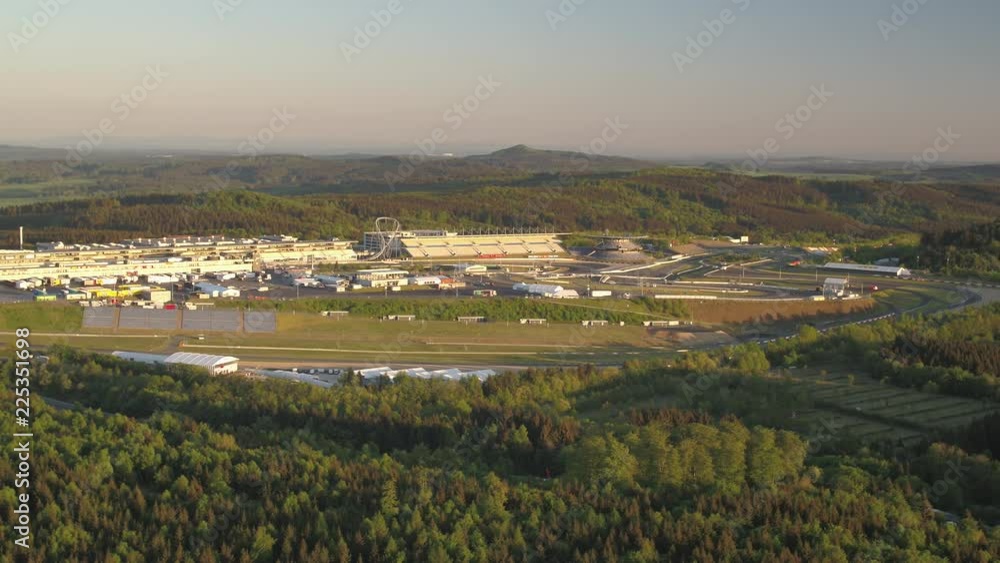 Nürburgring Drone moving left overview car race arena german landscape Eiffel forest sunny clear sky Nürburgring Drone moving left overview car race arena german landscape Eiffel forest sunny clear sky
