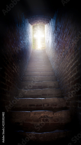 Light at end of tunnel in castle . Staircase leading to heaven or hell. Light cross of Christ . Walk to the cross . Sunbeams and cross . Jesus Christ . 