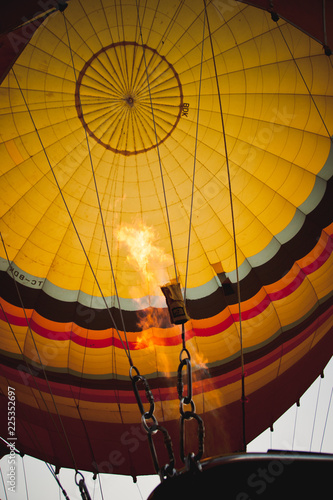 Goreme, Turkey - April 4, 2012: Hot air balloons for tourists flying over rock formations at sunrise in the valley of Cappadocia.
