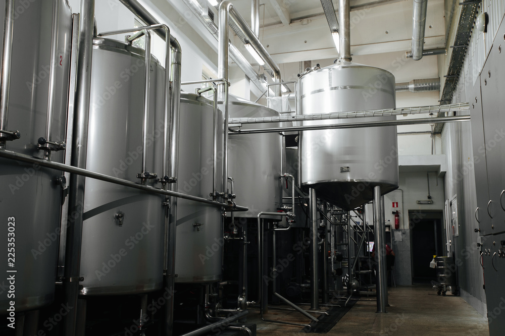 Modern brewery and equipment machinery tools for alcohol production. Steel vats or tanks and stainless pipes.