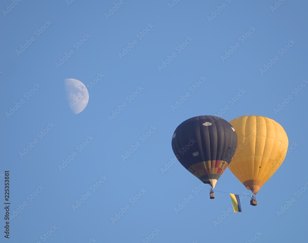 Fototapeta premium na tle księżyca latają dwa balony