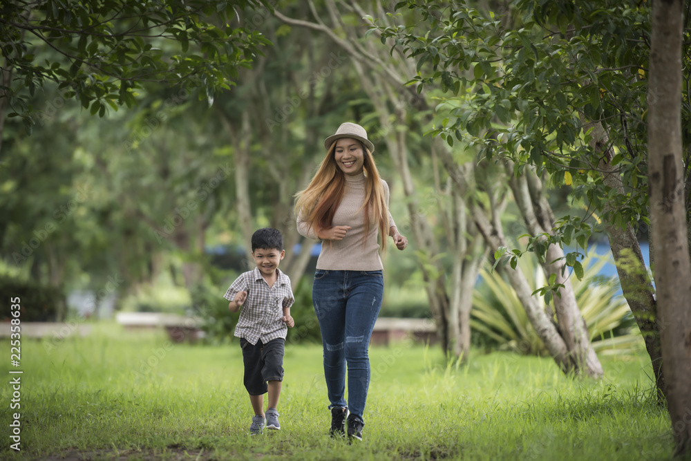 Obraz premium Portrait of mother and son happy walking together in the park holding hand. Family concept.