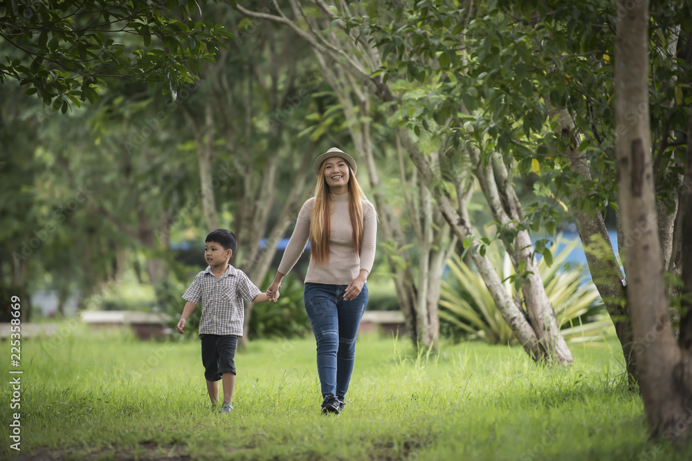 Portrait of mother and son happy walking together in the park holding hand. Family concept.