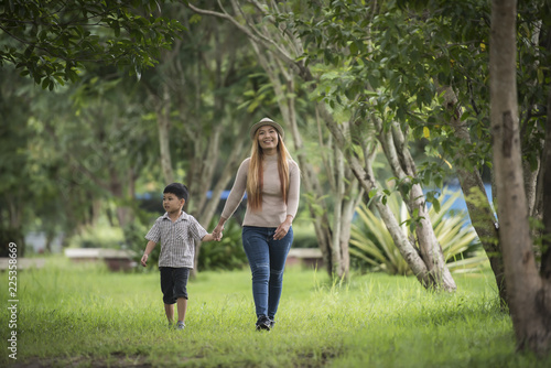 Portrait of mother and son happy walking together in the park holding hand. Family concept.