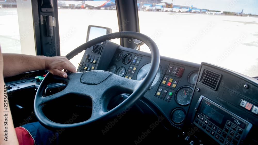 Closeup image of male hands on steering wheel while driving big heavy truck