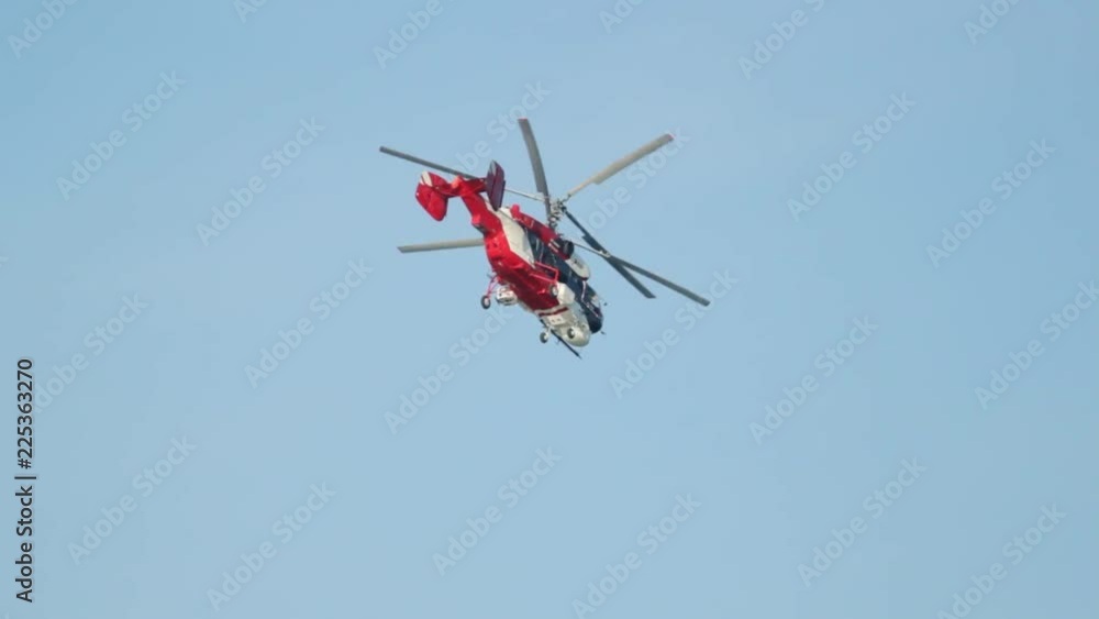 Red helicopter flying down against a clear sky without clouds Red helicopter flying down against a clear sky without clouds