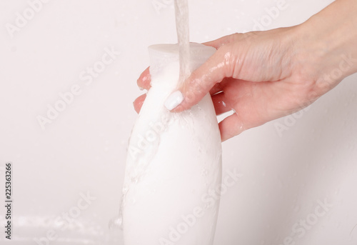 White bottle gel shower in hands water bath cosmetic care body