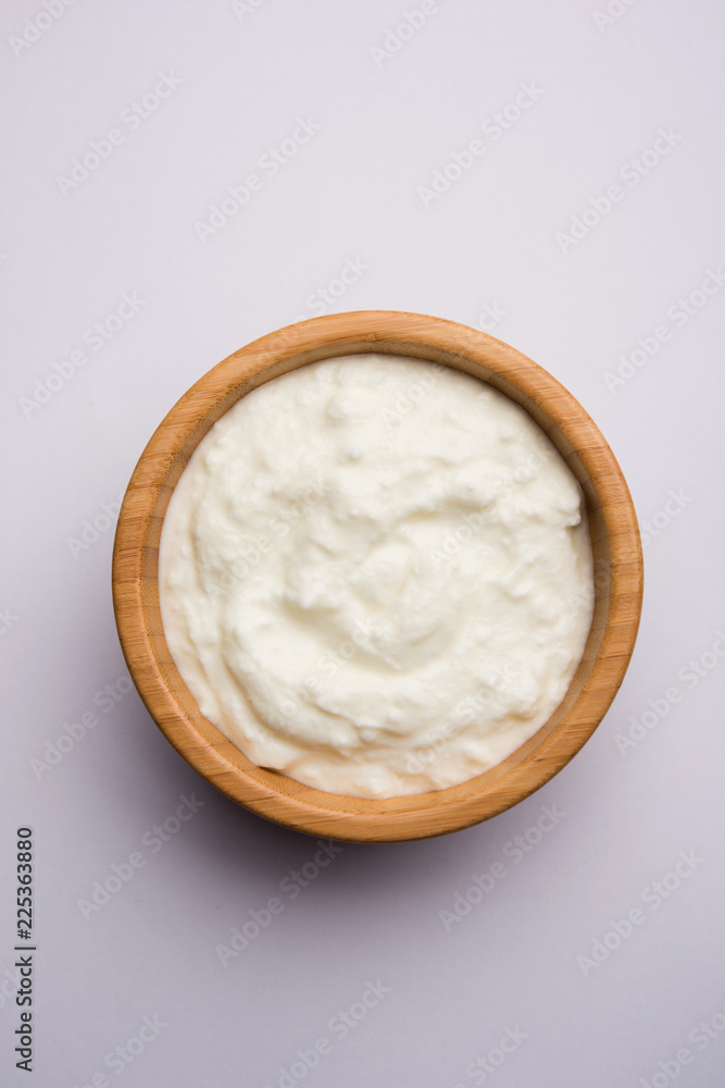Plain curd or yogurt or Dahi in Hindi, served in a bowl over moody background. Selective focus Plain curd or yogurt or Dahi in Hindi, served in a bowl over moody background. Selective focus