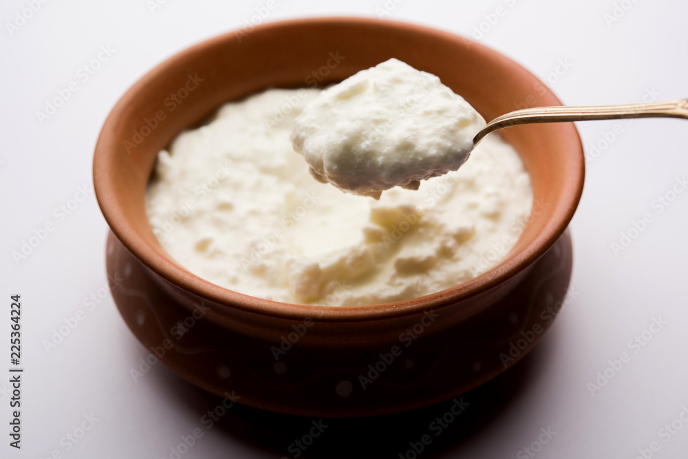 Plain curd or yogurt or Dahi in Hindi, served in a bowl over moody background. Selective focus Plain curd or yogurt or Dahi in Hindi, served in a bowl over moody background. Selective focus
