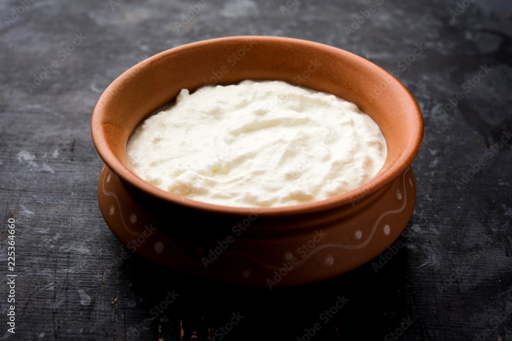 Plain curd or yogurt or Dahi in Hindi, served in a bowl over moody background. Selective focus Plain curd or yogurt or Dahi in Hindi, served in a bowl over moody background. Selective focus
