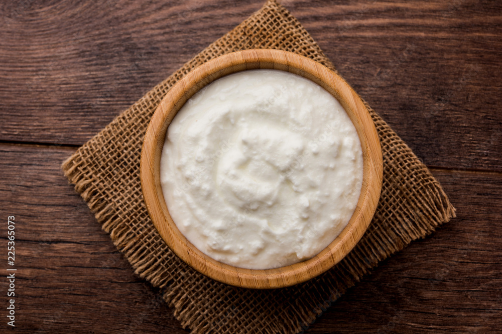 Plain curd or yogurt or Dahi in Hindi, served in a bowl over moody background. Selective focus Plain curd or yogurt or Dahi in Hindi, served in a bowl over moody background. Selective focus