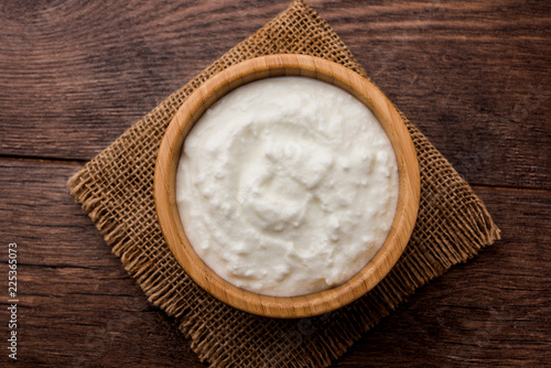 Plain curd or yogurt or Dahi in Hindi, served in a bowl over moody background. Selective focus