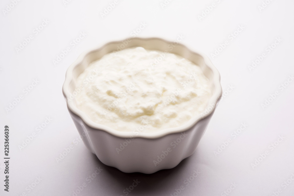Plain curd or yogurt or Dahi in Hindi, served in a bowl over moody background. Selective focus Plain curd or yogurt or Dahi in Hindi, served in a bowl over moody background. Selective focus