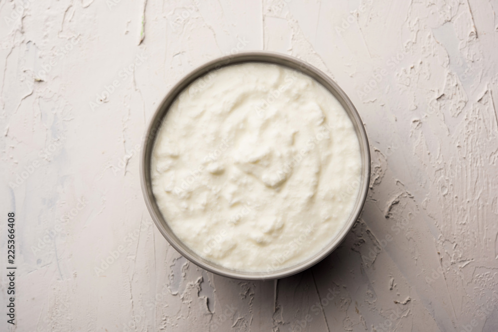 Plain curd or yogurt or Dahi in Hindi, served in a bowl over moody background. Selective focus Plain curd or yogurt or Dahi in Hindi, served in a bowl over moody background. Selective focus