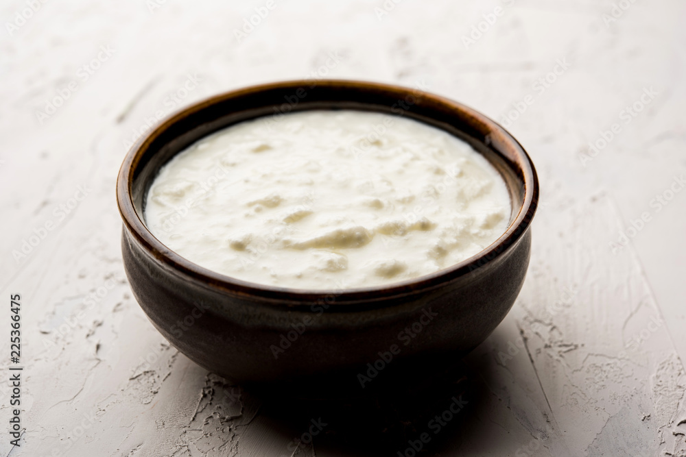 Plain curd or yogurt or Dahi in Hindi, served in a bowl over moody background. Selective focus Plain curd or yogurt or Dahi in Hindi, served in a bowl over moody background. Selective focus