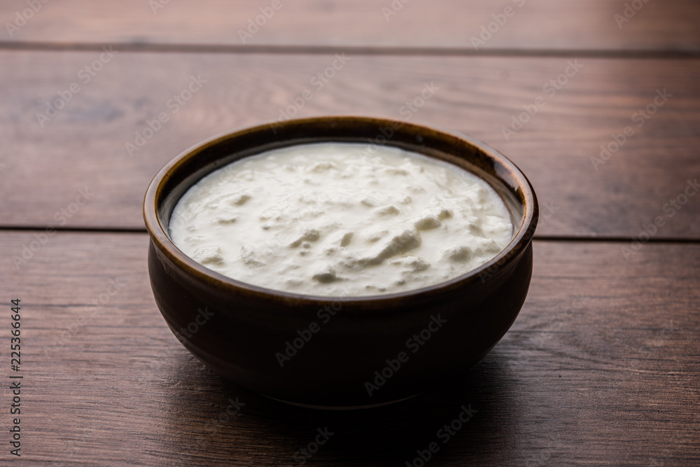 Plain curd or yogurt or Dahi in Hindi, served in a bowl over moody background. Selective focus Plain curd or yogurt or Dahi in Hindi, served in a bowl over moody background. Selective focus