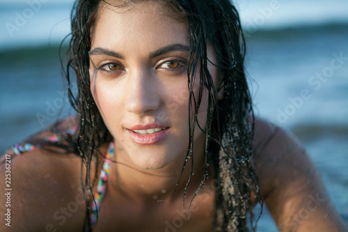 Close up portrait of a young woman with wet hair at the beach.